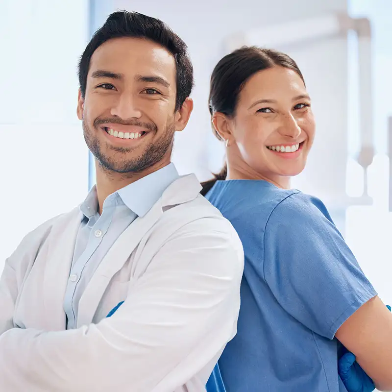 Doctors standing back to back and smiling