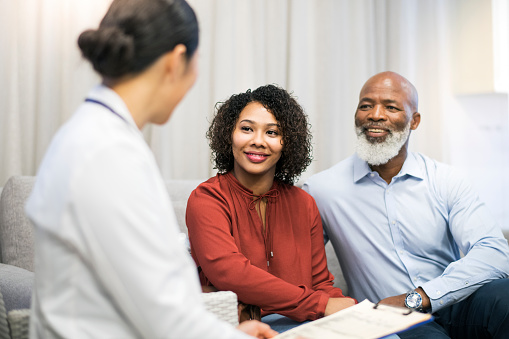 Older Black couple speaking with dentist about dental bridges vs dental implants at Mountain State Oral and Facial Surgery in Charleston, WV