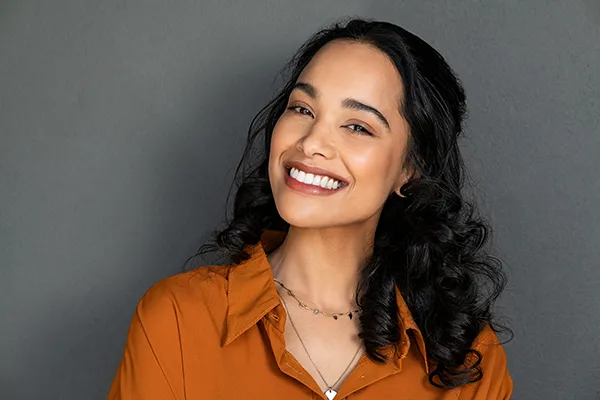 Beautiful Hispanic woman showing off her brilliant teeth and smiling with dental implants from Mountain State Oral and Facial Surgery in Ashland, KY